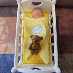Zuru Mini Baby Doll in Yellow Swaddle with Brown Teddy in White Cradle